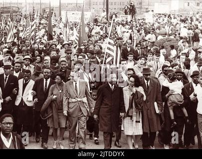 Martin Luther King, Jr. führt gewaltlose Demonstranten am 25. März 1965, dem letzten Tag der Selma-Montgomery-Märsche, nach Montgomery, Alabama, in Richtung der Stufen des Alabama State Capitol Building. In der ersten Reihe (von L nach R) sind A. Philip Randolph, John Lewis, Ralph Abernathy, Ruth Harris Bunch, Ralph Bunch, Martin Luther King, Coretta Scott King, Fred Shuttlesworth und Hosea Williams (das Mädchen hält) Stockfoto