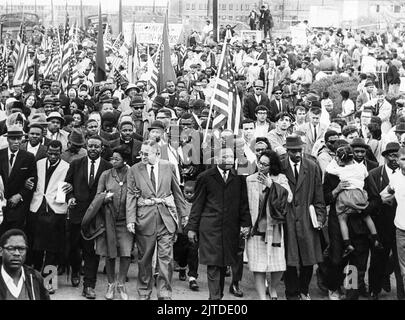 Martin Luther King, Jr. führt gewaltlose Demonstranten am 25. März 1965, dem letzten Tag der Selma-Montgomery-Märsche, nach Montgomery, Alabama, in Richtung der Stufen des Alabama State Capitol Building. In der ersten Reihe (von L nach R) sind A. Philip Randolph, John Lewis, Ralph Abernathy, Ruth Harris Bunch, Ralph Bunch, Martin Luther King, Coretta Scott King, Fred Shuttlesworth und Hosea Williams (das Mädchen hält) Stockfoto