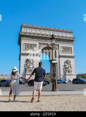 Machen Sie ein Paar auf einer Städtereise nach Paris und besuchen Sie die Avenue des Champs Elysees Paris France Arc De Triomphe. Männer und Frauen besuchen den Arc de Triomphe in Paris Stockfoto