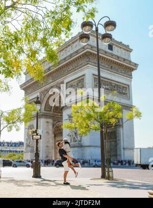 Machen Sie ein Paar auf einer Städtereise nach Paris und besuchen Sie die Avenue des Champs Elysees Paris France Arc De Triomphe. Männer und Frauen besuchen den Arc de Triomphe in Paris Stockfoto