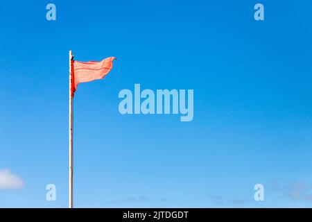 Rote Warnfahne und Stange mit blauem Meer im Hintergrund Stockfotografie -  Alamy