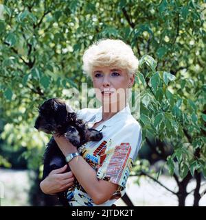 Ingrid Steeger, deutsche Schauspielerin, hier mit ihr geliebten Rauhaardackel, Deutschland, 1983. Ingrid Steeger, deutsche Schauspielerin, hier mit ihrem geliebten rauhaarigen Dackel, Deutschland, 1983. Stockfoto