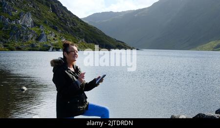 Reifes Weibchen, das am Ufer des Glenbeg Lake, Ardgroom, County Cork, Irland, skizziert - John Gollop Stockfoto