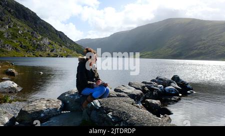 Reifes Weibchen, das am Ufer des Glenbeg Lake, Ardgroom, County Cork, Irland, skizziert - John Gollop Stockfoto