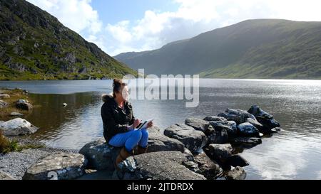 Reifes Weibchen, das am Ufer des Glenbeg Lake, Ardgroom, County Cork, Irland, skizziert - John Gollop Stockfoto