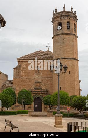 Baños de la Encina Jaén Spanien - 09 12 2021: Vorderfassade und Blick auf den Turm auf die Iglesia de San Mateo, eine ikonische gotische und romanische Kirche Stockfoto