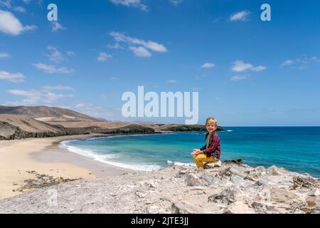 Kleiner Junge, der die Strandlandschaft namens Caleta del Congrio im Nationalpark Los Ajaches auf Lanzarote, Kanarische Inseln, Spanien, genießt Stockfoto