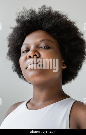 Low-Angle-Ansicht der selbstbewussten afroamerikanischen plus size Frau in Sportswear isoliert auf grau, Stock Bild Stockfoto