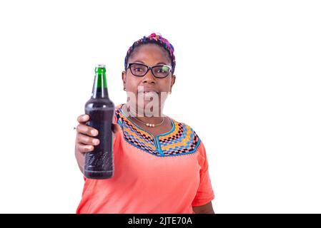 Eine afrikanerin in Gläsern, die auf einem weißen Hintergrund stehen und eine Flasche Bier geben. Stockfoto