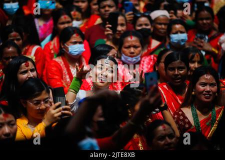 Kathmandu, Nepal. 30. August 2022. Nepalesische Hindu-Frauen tanzen und singen während des Teej-Festivals im Pashupathinath-Tempel in Kathmandu. Verheiratete und unverheiratete Frauen beobachten das Fasten. Verheiratete Frauen verzichten strikt auf Essen und Trinken und glauben, dass ihre Hingabe an gott mit Langlebigkeit, Frieden und Wohlstand für ihre Ehemänner und ihre Familie gesegnet wird. Unverheiratete Frauen beobachten das Fasten in der Hoffnung, mit einem guten Mann gesegnet zu werden, indem sie beten, singen und tanzen. (Foto: Skanda Gautam/SOPA Images/Sipa USA) Quelle: SIPA USA/Alamy Live News Stockfoto