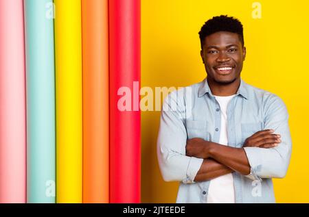 Foto von positiv bauen Store Worker Kerl Cross-Hände Einzelhandel verkaufen Papier Wechsel Rollen isoliert Glanz Farbe Hintergrund Stockfoto