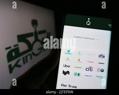 Person mit Smartphone und Website der Saudi Arabian Kingdom Holding Company (KHC) auf dem Bildschirm mit Logo. Konzentrieren Sie sich auf die Mitte des Telefondisplays. Stockfoto