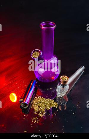 Vertikale Aufnahme von Bong und Rohr mit Unkraut gefüllt. Set von Zubehör zum Rauchen von Cannabis Marihuana. Stockfoto
