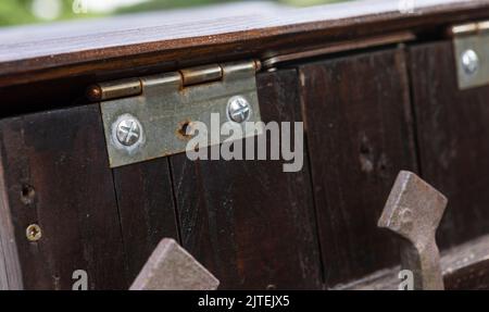 Metallscharnier mit Holz verschraubt - Messing Scharnier auf Teakholz Stockfoto