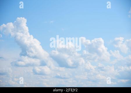 Blauer Himmel Hintergrund mit weißen flauschigen Cumulus Wolken. Panorama von weißen, flauschigen Wolken am blauen Himmel. Wunderschöner, riesiger blauer Himmel mit erstaunlichen verstreuten Stockfoto