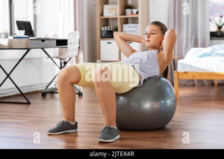 Teenager-Mädchen, die zu Hause auf Übungsball trainiert Stockfoto