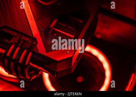Eine Grafikkarte mit futuristischem Design. Leistungsstarke Gaming-Grafikkarte für Videospiele und Kryptowährungen-Mining. Dunkler Schlüssel, Draufsicht - GPU in einem Gamin Stockfoto