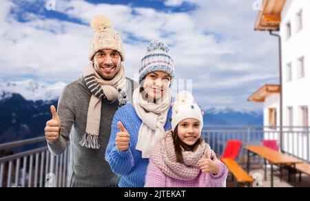 Glückliche Familie, die im Winter Daumen hoch zeigte Stockfoto