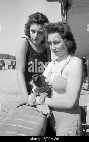 Zwei junge Frauen genießen die Frühlingssonne über Berlin im Schwimmbad Wannsee, Deutschland 1947. Stockfoto