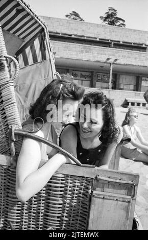 Zwei junge Frauen genießen die Frühlingssonne über Berlin im Strandkorb vom Schwimmbad Wannsee, Deutschland 1947. Stockfoto