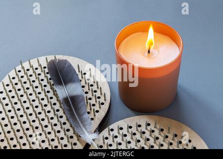 Sadhu Bretter zum Stehen auf Metallnägeln mit brennender Kerze und Feder. Yoga und Meditationskonzept Stockfoto
