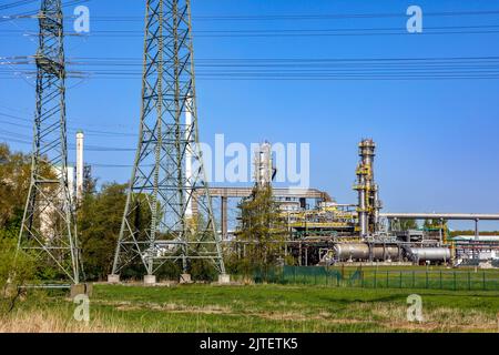 Hochspannungsleitung am Holstendamm in Brunsbüttel, TotalEnergies Bitumen Deutschland GmbH im Hintergrund Stockfoto