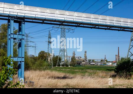 Hochspannungsleitung am Holstendamm in Brunsbüttel, TotalEnergies Bitumen Deutschland GmbH im Hintergrund Stockfoto