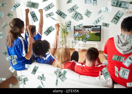 Fröhliche Fußballfans, die bei Geldregen Fernsehen Stockfoto