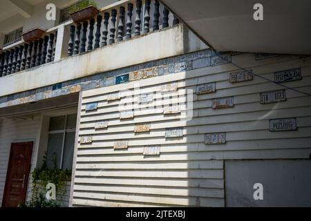 Haufen von Kfz-Kennzeichen, die an der Wand eines Gebäudes im Freien hängen Stockfoto