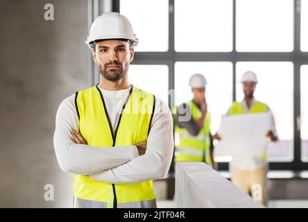 Männlicher Architekt in Helm und Sicherheit West im Büro Stockfoto