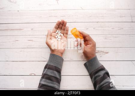 Draufsicht auf Männer, die Medikamente auf dem Tisch einnehmen Stockfoto