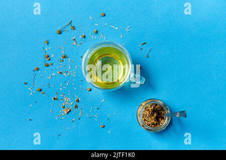 tasse Kräutertee und trockene Kamillenblüten im Glas Stockfoto