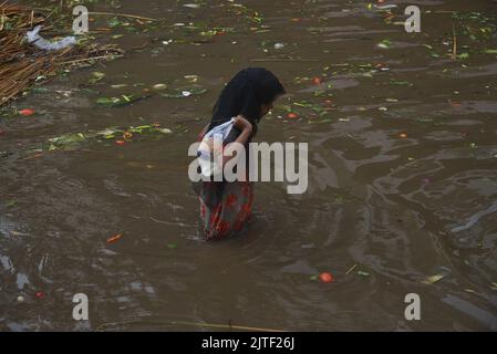 Lahore, Pakistan. 29. August 2022. Pakistanische Menschen unterwegs und beschäftigt sich am Badami bagh Gemüsemarkt während der starken Monsunregen in Lahore, Pakistan, am 29. August 2022. Der Monsunregen hat einen 20-Jahres-Rekord gebrochen, als die Provinzhauptstadt innerhalb von acht Stunden 248mm von Niederschlägen erhielt. Mindestens fünf Menschen sind tot und viele verletzt, nachdem zwei Dach- und Mauereinstürze und andere Vorfälle in der Provinzhauptstadt Lahore einstürzten. (Foto von Rana Sajid Hussain/Pacific Press/Sipa USA) Quelle: SIPA USA/Alamy Live News Stockfoto