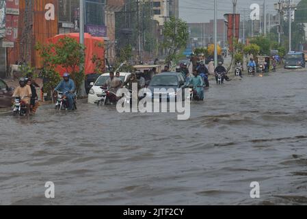 Pakistanische Menschen unterwegs und beschäftigt sich am Badami bagh Gemüsemarkt während der starken Monsunregen in Lahore, Pakistan, am 29. August 2022. Der Monsunregen hat einen 20-Jahres-Rekord gebrochen, als die Provinzhauptstadt innerhalb von acht Stunden 248mm von Niederschlägen erhielt. Mindestens fünf Menschen sind tot und viele verletzt, nachdem zwei Dach- und Mauereinstürze und andere Vorfälle in der Provinzhauptstadt Lahore einstürzten. (Foto von Rana Sajid Hussain/Pacific Press/Sipa USA) Stockfoto