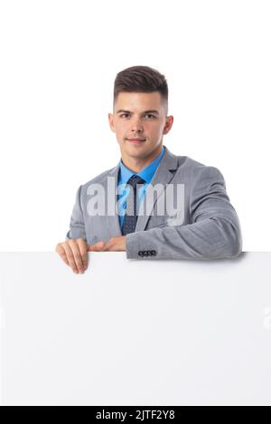 Junger Mann in Anzug zeigt Banner Whiteboard-Zeichen isoliert auf weißem Hintergrund Stockfoto