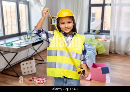 Mädchen im Bau Helm mit Lineal zu Hause Stockfoto