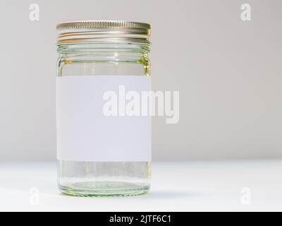 Silberner Glasbecher mit Schraubverschluss und sauberem weißen Etikett Stockfoto