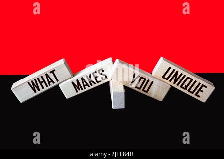 Was macht Sie einzigartig geschrieben auf Holzblöcken und rot und schwarz Hintergrund Stockfoto