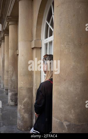 Frau, die in Bath zwischen einer Reihe von Säulen steht (Aug22) Stockfoto