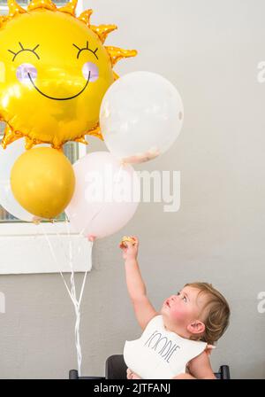 Kleines Mädchen (12-17 Monate) mit Ballons Stockfoto