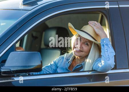 Blonde Frau im Auto mit Cowboyhut Stockfoto