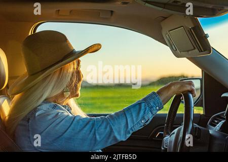 Blonde Frau im Auto mit Cowboyhut Stockfoto