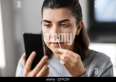 Frau, die zu Hause den Coronavirus-Test selbst testet Stockfoto