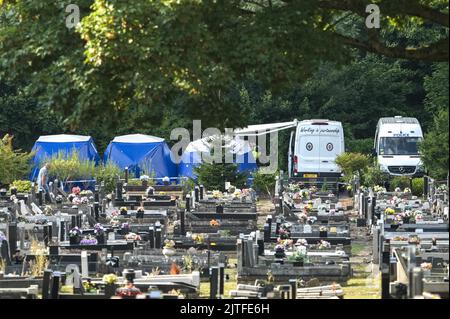 Tipton Cemetery, West Midds August 30. 2022 - die Polizei durchsiebt die Erde von einem sprung, wo am Samstag, dem 27. August, menschliche Überreste auf dem Tipton Cemetery, West Midlands, gefunden wurden. Drei blaue forensische Zelte waren zu sehen, zusammen mit mehreren Polizeiwagen, Forensik-Beamten in weißen Anzügen und einer Kordon am Ende des Friedhofs, in der Nähe des Spielplatzes der Akademie Q3. Ein Sprecher der Polizei von West Midlands sagte: ‘Wir untersuchen, nachdem am Samstagabend (27. August) auf dem Tipton Cemetery in der Alexandra Road menschliche Überreste gefunden wurden. Das Gebiet wurde für weitere Durchsuchungen abgesperrt Stockfoto