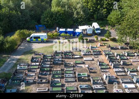 Tipton Cemetery, West Midds August 30. 2022 - die Polizei durchsiebt die Erde von einem sprung, wo am Samstag, dem 27. August, menschliche Überreste auf dem Tipton Cemetery, West Midlands, gefunden wurden. Drei blaue forensische Zelte waren zu sehen, zusammen mit mehreren Polizeiwagen, Forensik-Beamten in weißen Anzügen und einer Kordon am Ende des Friedhofs, in der Nähe des Spielplatzes der Akademie Q3. Ein Sprecher der Polizei von West Midlands sagte: ‘Wir untersuchen, nachdem am Samstagabend (27. August) auf dem Tipton Cemetery in der Alexandra Road menschliche Überreste gefunden wurden. Das Gebiet wurde für weitere Durchsuchungen abgesperrt Stockfoto