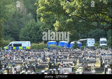 Tipton Cemetery, West Midds August 30. 2022 - die Polizei durchsiebt die Erde von einem sprung, wo am Samstag, dem 27. August, menschliche Überreste auf dem Tipton Cemetery, West Midlands, gefunden wurden. Drei blaue forensische Zelte waren zu sehen, zusammen mit mehreren Polizeiwagen, Forensik-Beamten in weißen Anzügen und einer Kordon am Ende des Friedhofs, in der Nähe des Spielplatzes der Akademie Q3. Ein Sprecher der Polizei von West Midlands sagte: ‘Wir untersuchen, nachdem am Samstagabend (27. August) auf dem Tipton Cemetery in der Alexandra Road menschliche Überreste gefunden wurden. Das Gebiet wurde für weitere Durchsuchungen abgesperrt Stockfoto