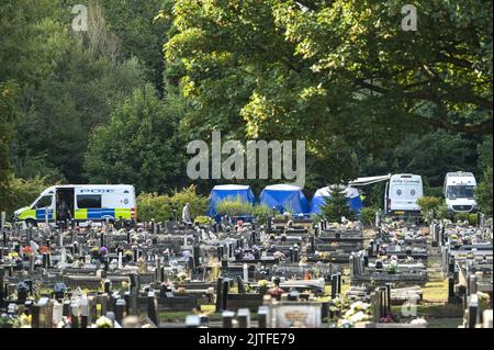 Tipton Cemetery, West Midds August 30. 2022 - die Polizei durchsiebt die Erde von einem sprung, wo am Samstag, dem 27. August, menschliche Überreste auf dem Tipton Cemetery, West Midlands, gefunden wurden. Drei blaue forensische Zelte waren zu sehen, zusammen mit mehreren Polizeiwagen, Forensik-Beamten in weißen Anzügen und einer Kordon am Ende des Friedhofs, in der Nähe des Spielplatzes der Akademie Q3. Ein Sprecher der Polizei von West Midlands sagte: ‘Wir untersuchen, nachdem am Samstagabend (27. August) auf dem Tipton Cemetery in der Alexandra Road menschliche Überreste gefunden wurden. Das Gebiet wurde für weitere Durchsuchungen abgesperrt Stockfoto