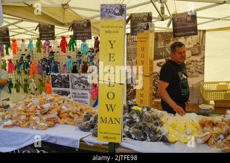 Ballycastle, Vereinigtes Königreich. 30. August 2022. Man verkauft traditionelle Yellowman-Süßigkeiten und Dulse (getrocknete Algen) am Verkaufsstand während des Abschlusstages von Irlands ältester Messe in der Küstenstadt Ballycastle an der Nordküste von North Antrim, die ein Feiertagswochenende voller Handel und ein Programm voller Unterhaltung, lokaler und internationaler Küche auf der Ould Lammas Fair abschließt. Quelle: Steve Nimmons/Alamy Live News Stockfoto