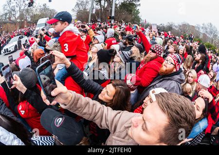 ATHEN, GA – 15. JANUAR 2022: Tausende UGA-Fußballfans kommen auf die Lumpkin Street, um bei der Parade zur Nationalmeisterschaft in Georgien zu feiern. Stockfoto