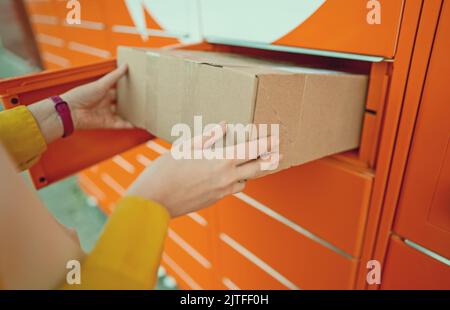 Frau, die per automatisiertem Postterminal Post versendet. Stockfoto